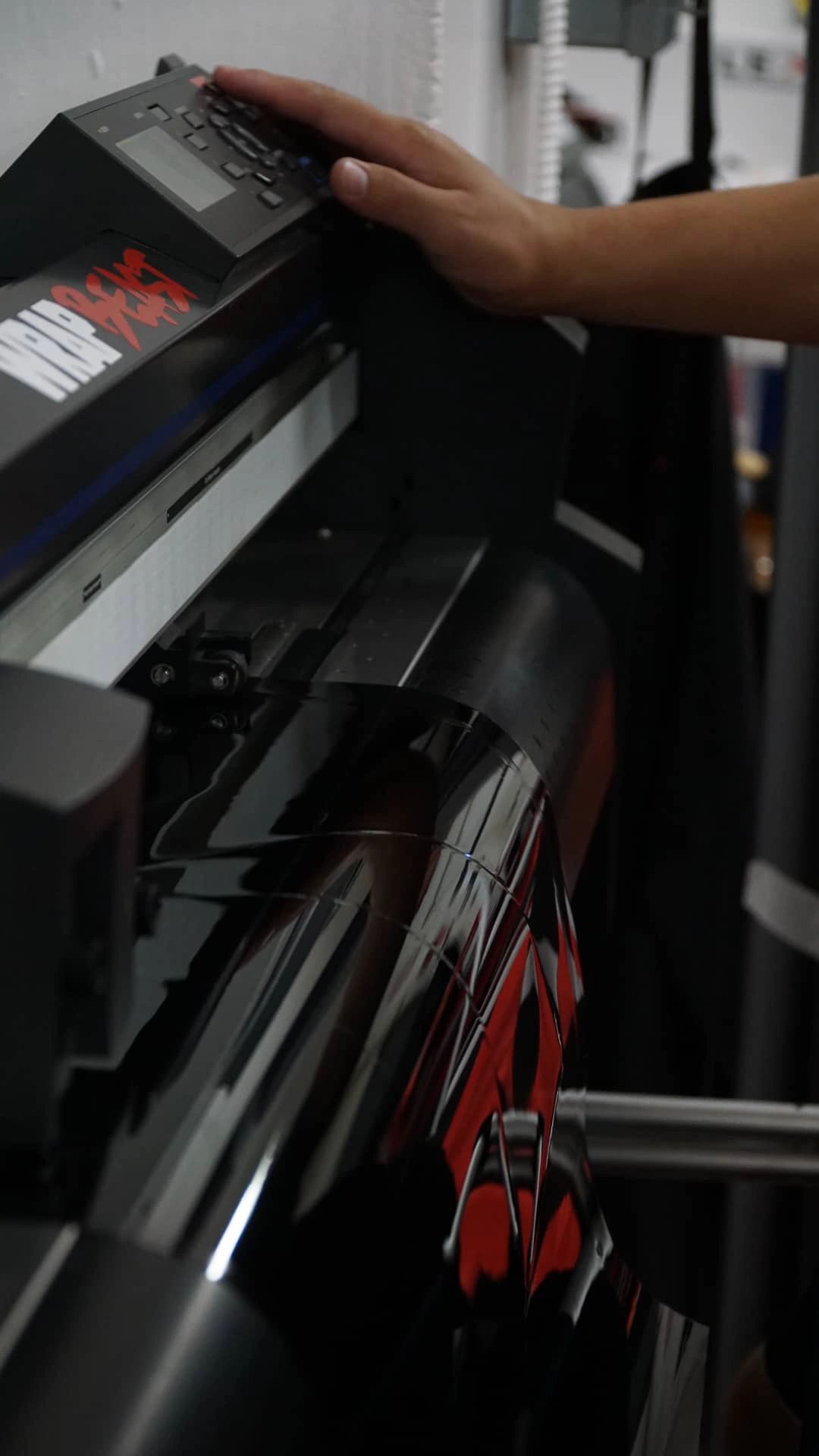 Tint film plotter cutting window tint to a vehicle-specific pattern